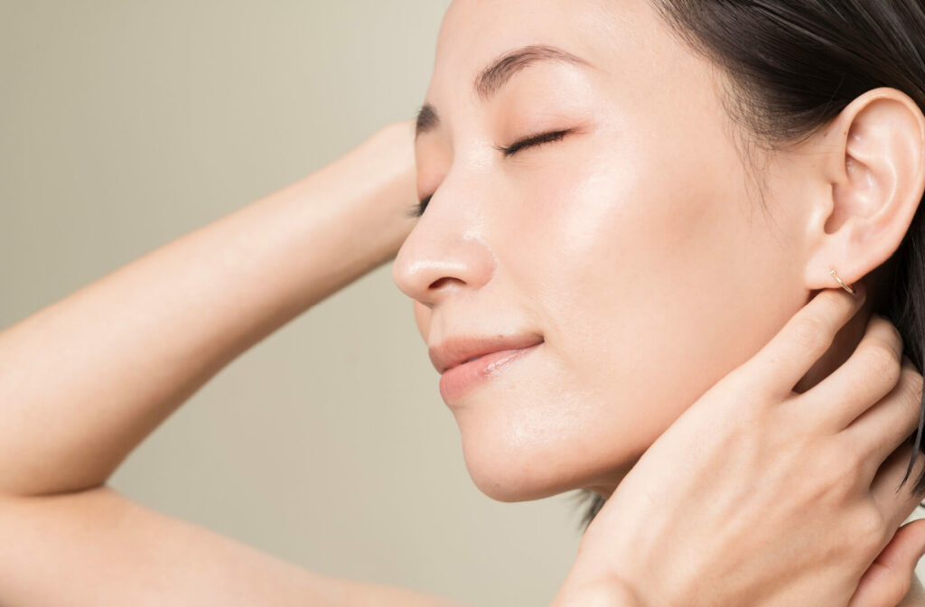 Side profile of a woman with glowing skin and a firm jawline, demonstrating the skin tightening and muscle stimulation benefits of a triLift facial.